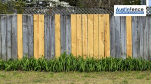 wooden fence with some new replaced panels